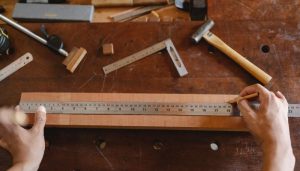régua metálica sobre pedaço de madeira em mesa de marceneiro
