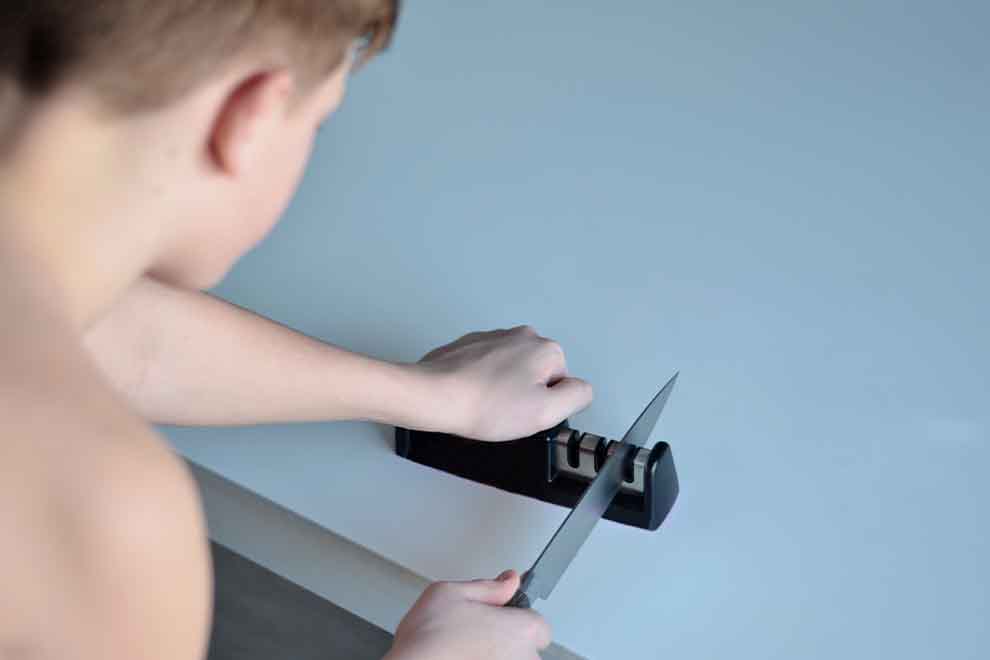 amolador manual Criança afiando uma faca com um afiador