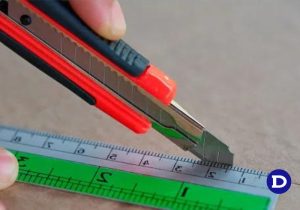 Homem cortando uma superfície com estilete