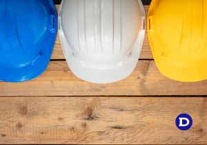 Três capacete na cor azul, branco e amarelo da esquerda para a direita