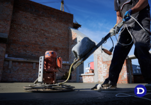 Homem utilizando uma máquina para espalhar o cimento queimado
