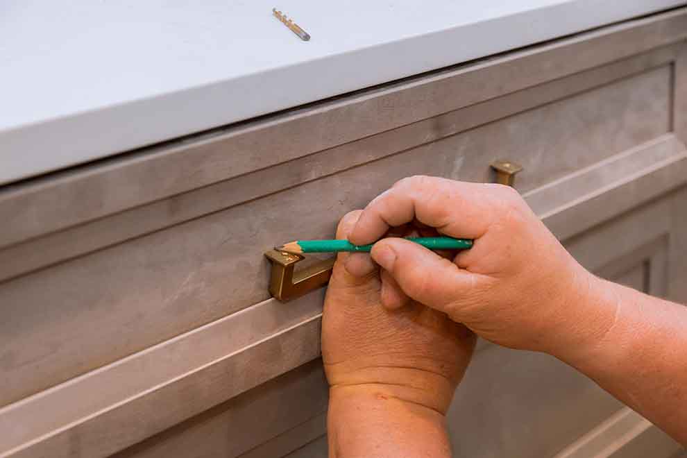 Uma pessoa medindo o puxador de gaveta