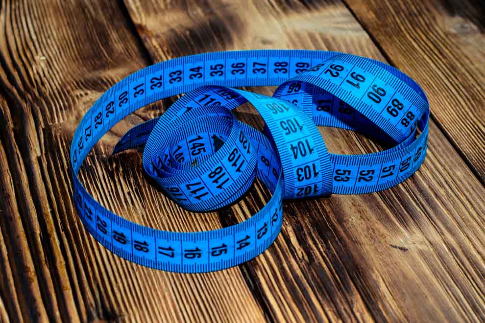 trena Fita métrica azul sobre superfície de madeira