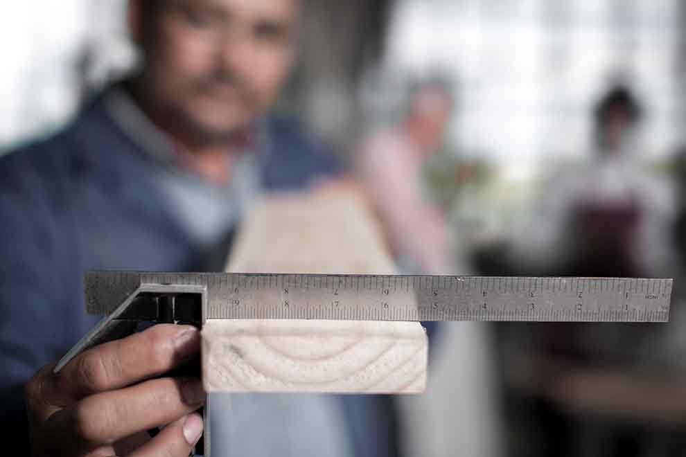 esquadro Homem medindo madeira com régua em oficina